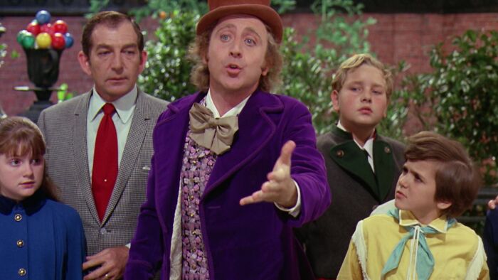 Willy Wonka telling something to his guest 