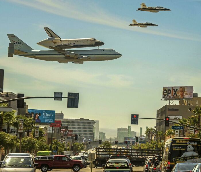 The Space Shuttle Carried On A 747 And Being Escorted By Two F-18’s