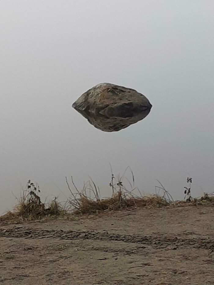 Explanation: The Rock Is Just Reflecting In Some Water That You Can't See Because Of Fog