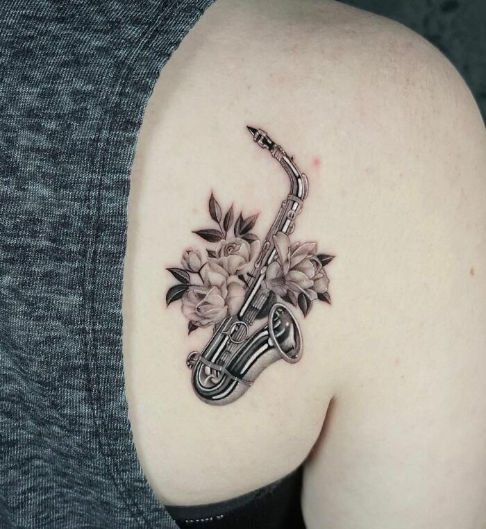 Realistic saxophone and flowers tattoo