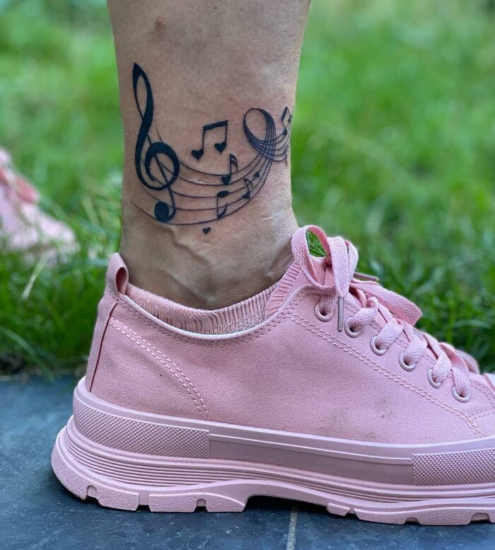 Black music tattoo on leg