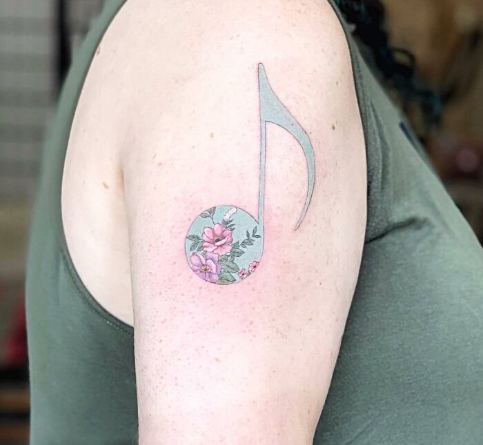 Pastel blue note tattoo with flowers