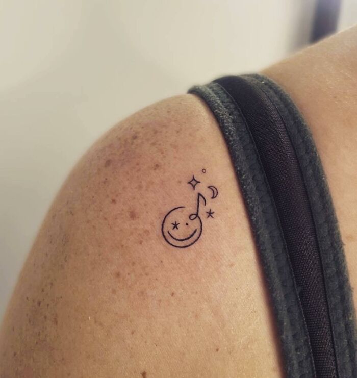 Small musical smile tattoo on shoulder
