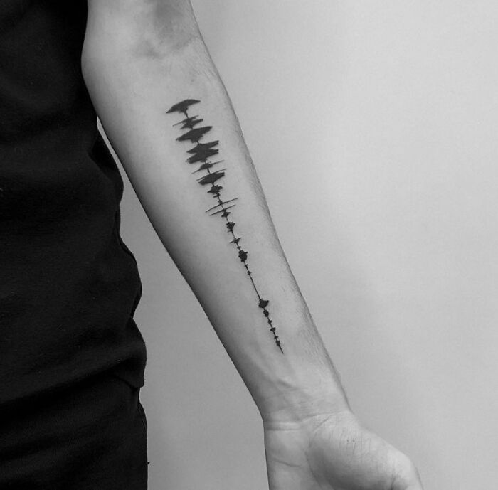 Black sound wave tattoo on arm