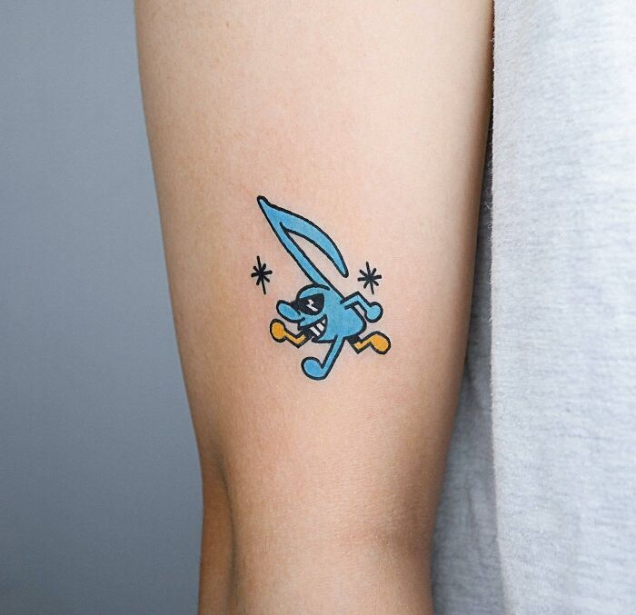 Cartoony Blue music note arm tattoo
