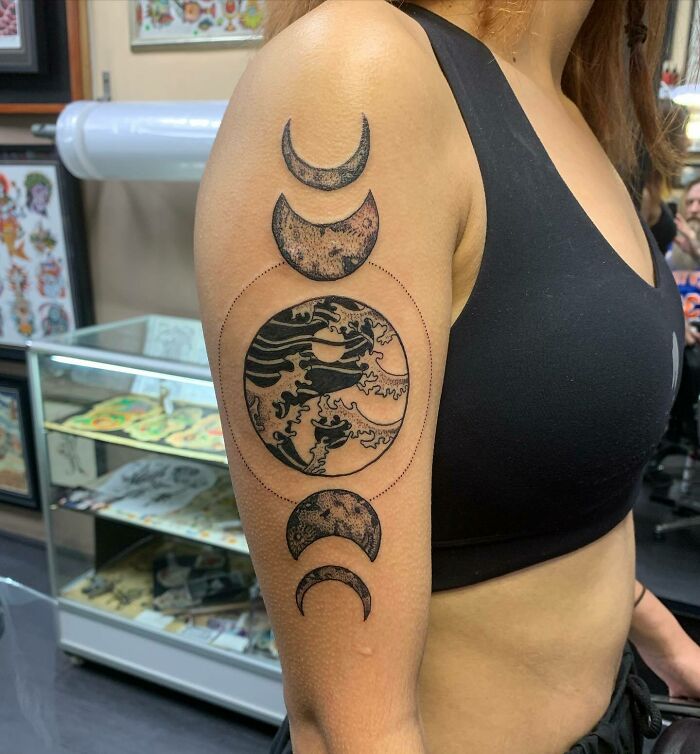 Yin yang symbol and moon phases arm tattoo