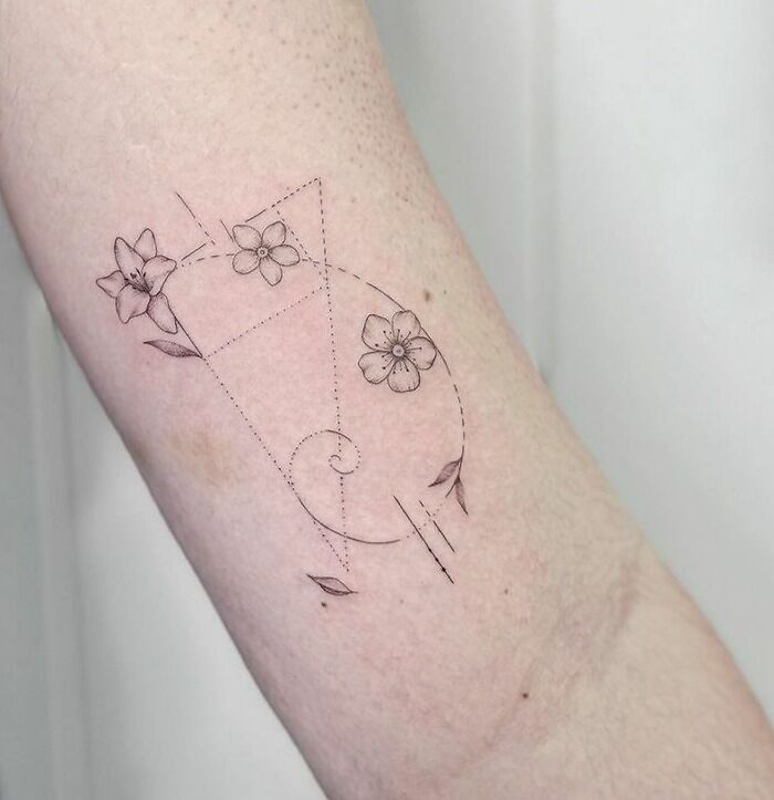 Delicate floral fibonacci arm tattoo
