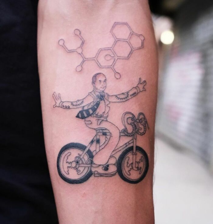 Albert Hoffman happy riding a bike tattoo on arm