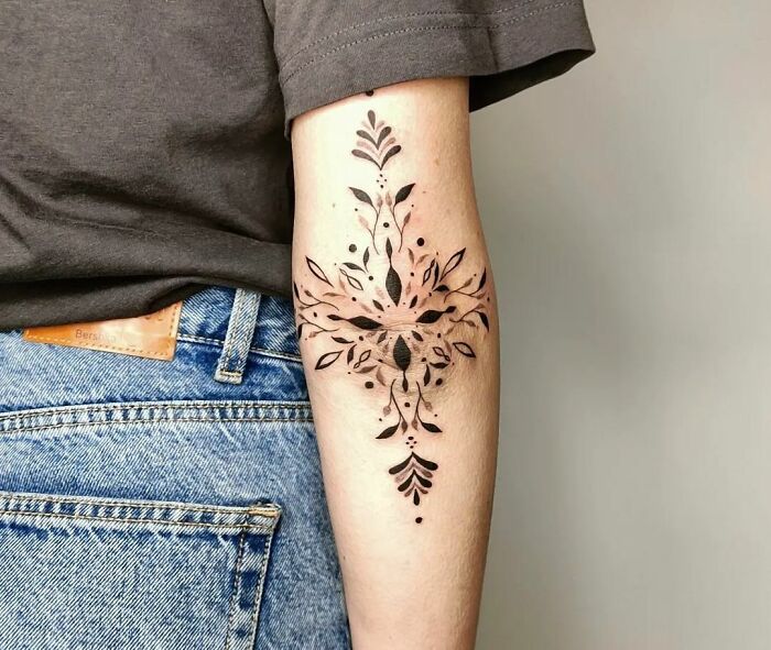 Symmetrical ornaments tattoo on the elbow
