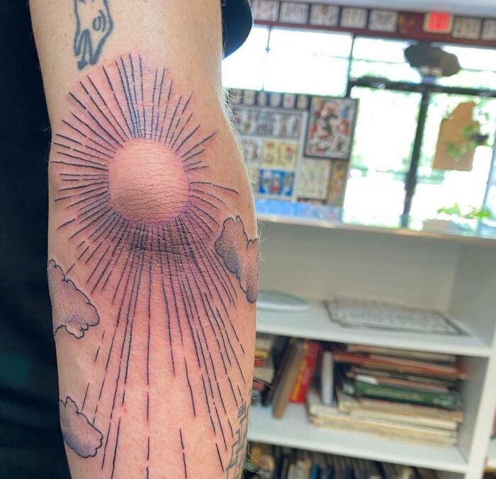 Sun rays elbow tattoo