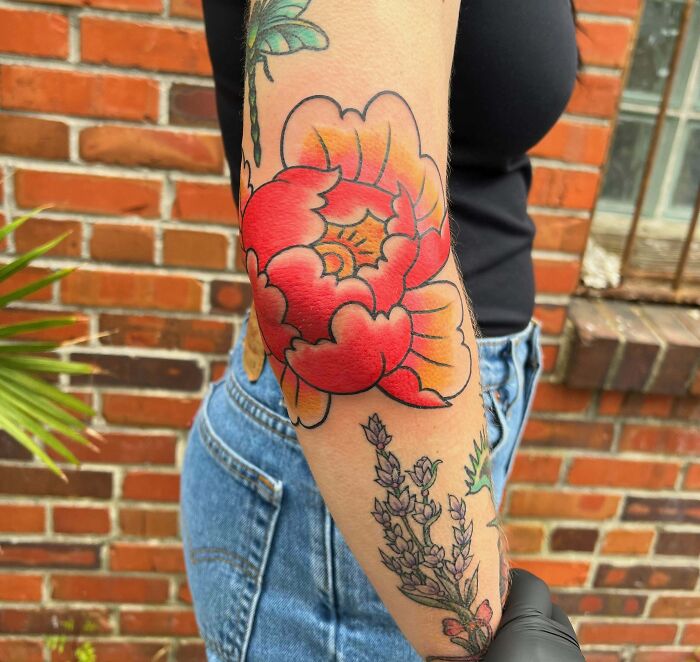 Red flower elbow tattoo