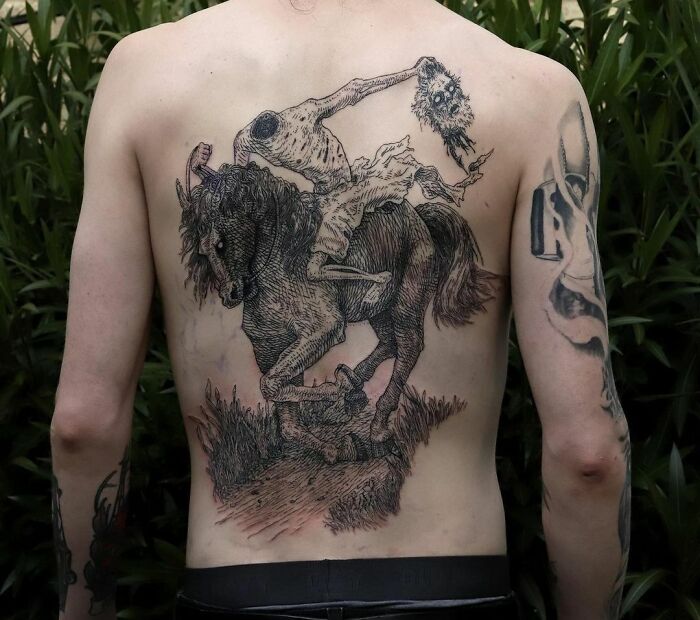 Back with a detailed gothic tattoo of a headless horseman, showcasing intricate design and texture.