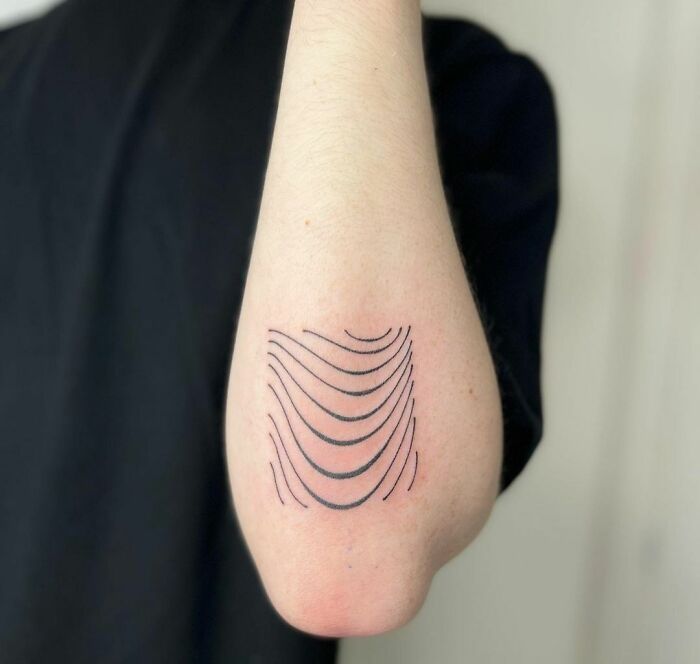 Curved lines tattoo on the elbow