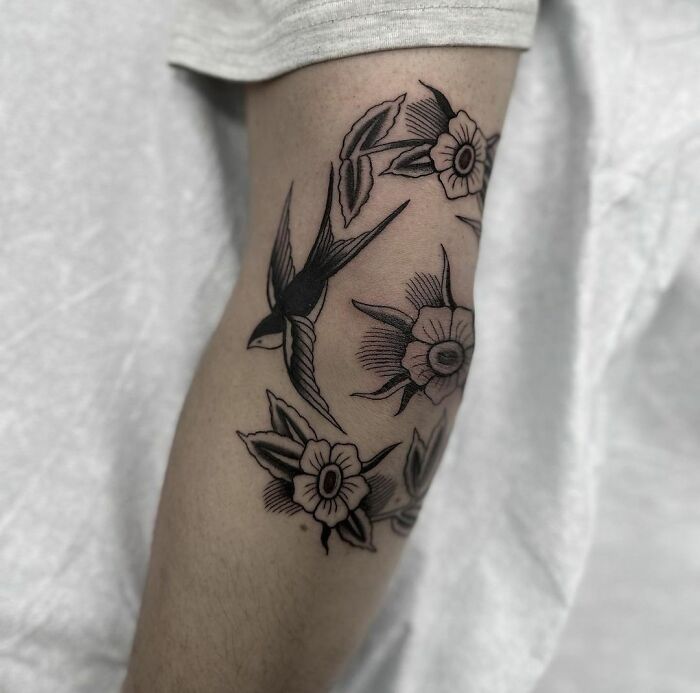 Flowers and bird tattoo on the elbow