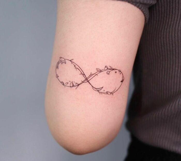 infinity symbol covered in flowers tricep tattoo