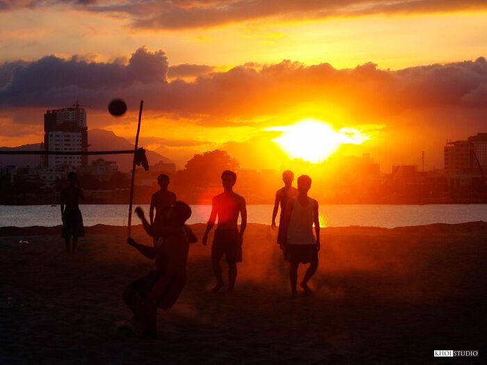 Young People Play Soccer On The Banks Of The Han River In Da Nang City At Sunset