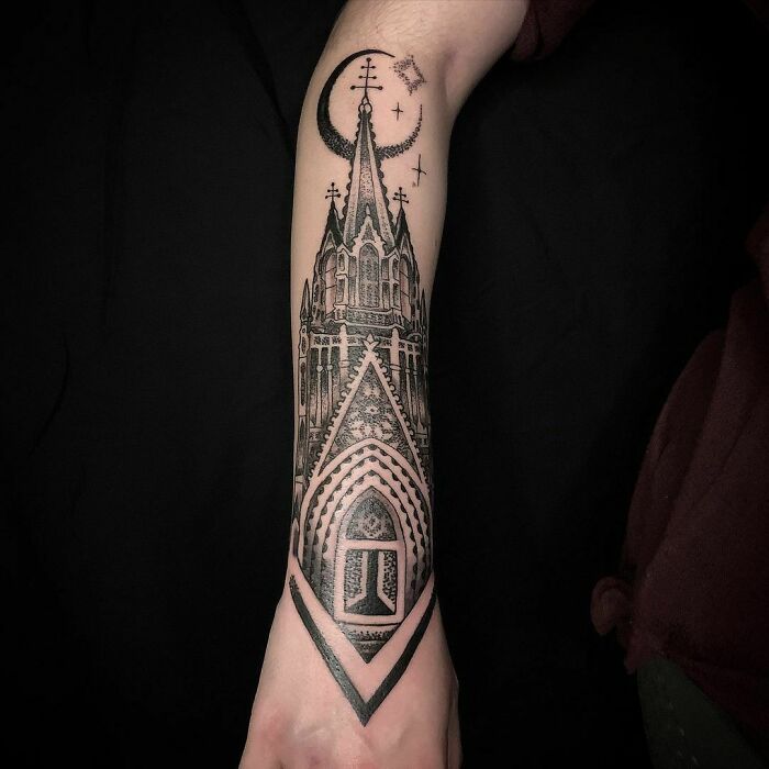 Gothic tattoo of a cathedral design on a forearm, featuring intricate architectural details and celestial symbols.