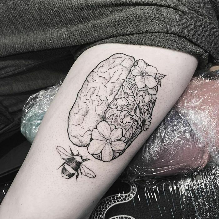 Brain with flowers and bee arm tattoo 