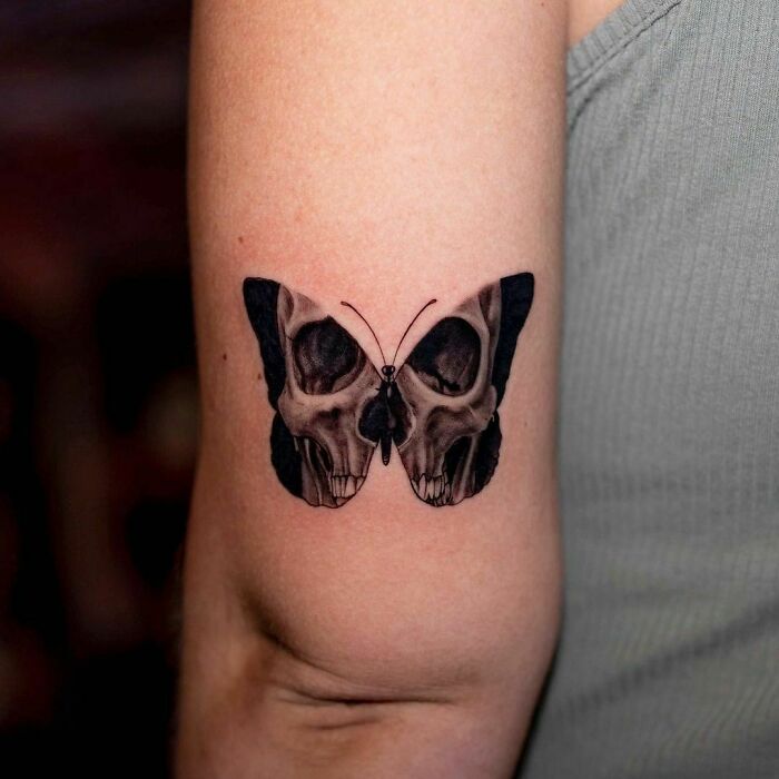 Butterfly and skull elbow tattoo