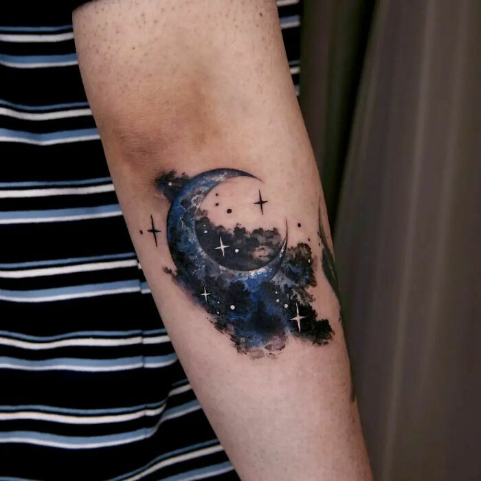 Moon and night sky tattoo on the elbow