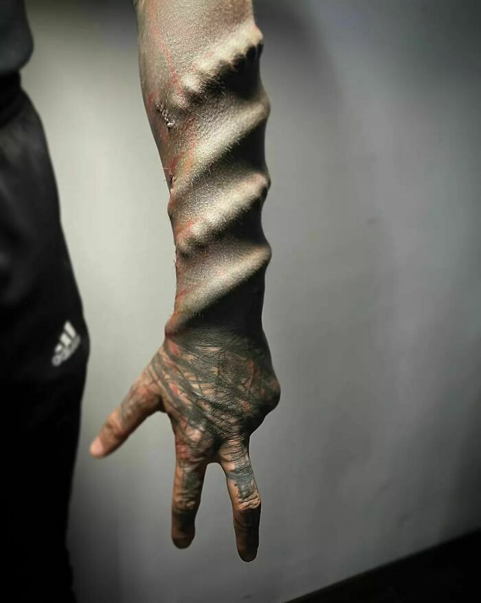 Tattooed arm of a 35-year-old individual identified as ‘Black Alien', showcasing unique skin modifications. Tattooed arm of a 35-year-old individual identified as ‘Black Alien', showcasing unique skin modifications.