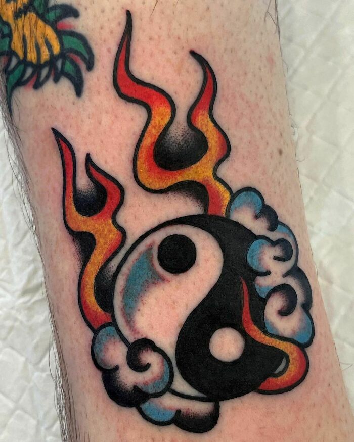 Yin Yang symbol in flames and clouds tattoo