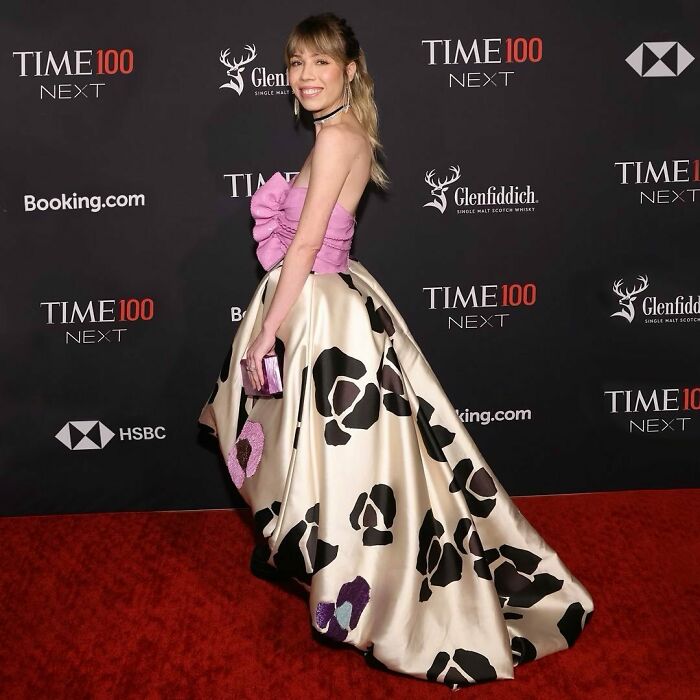 Woman in a pink top and patterned skirt on the red carpet at a Time 100 event. Woman in a pink top and patterned skirt on the red carpet at a Time 100 event.