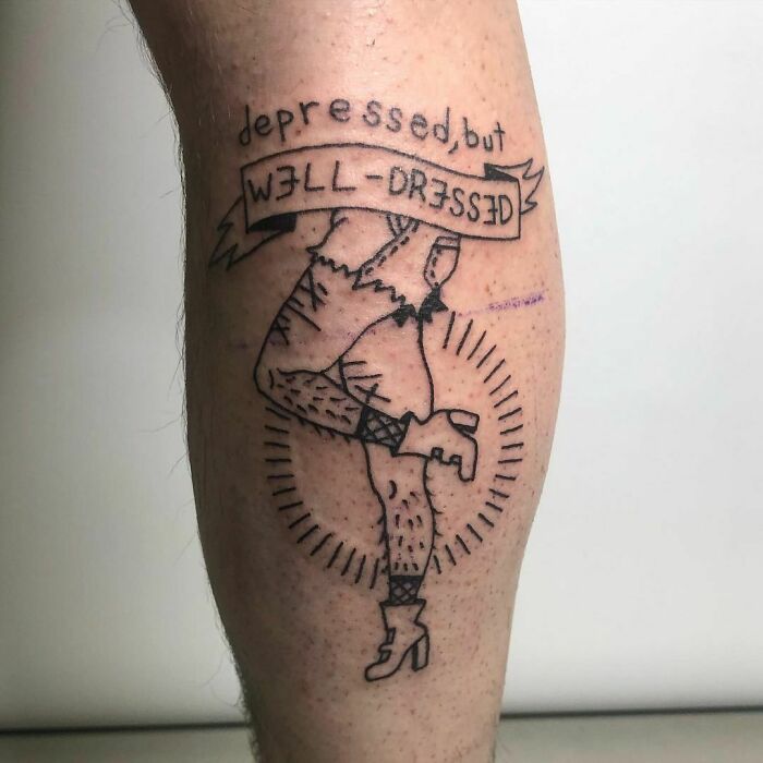 "Depressed, But Well-Dressed" phrase with human legs wearing shorts and boots tattoo