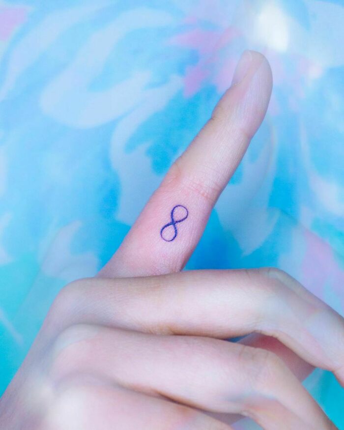 watercolor infinity tattoo on the finger