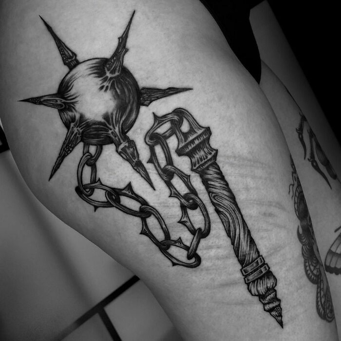 Gothic tattoo on arm featuring a spiked mace and chain for unique inspiration.