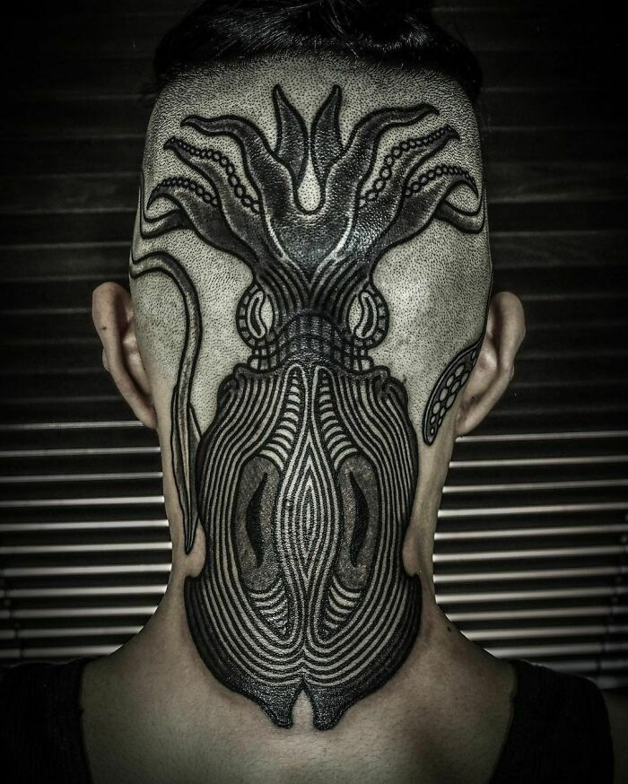 Intricate gothic tattoo design of a squid on the back of a shaved head, showcasing bold lines and symmetry.