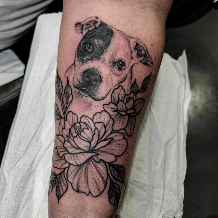 Dog and flowers memorial forearm tattoo