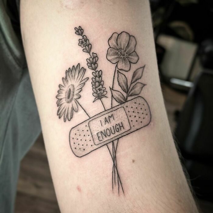 "I Am Enough" patch and flowers tattoo 