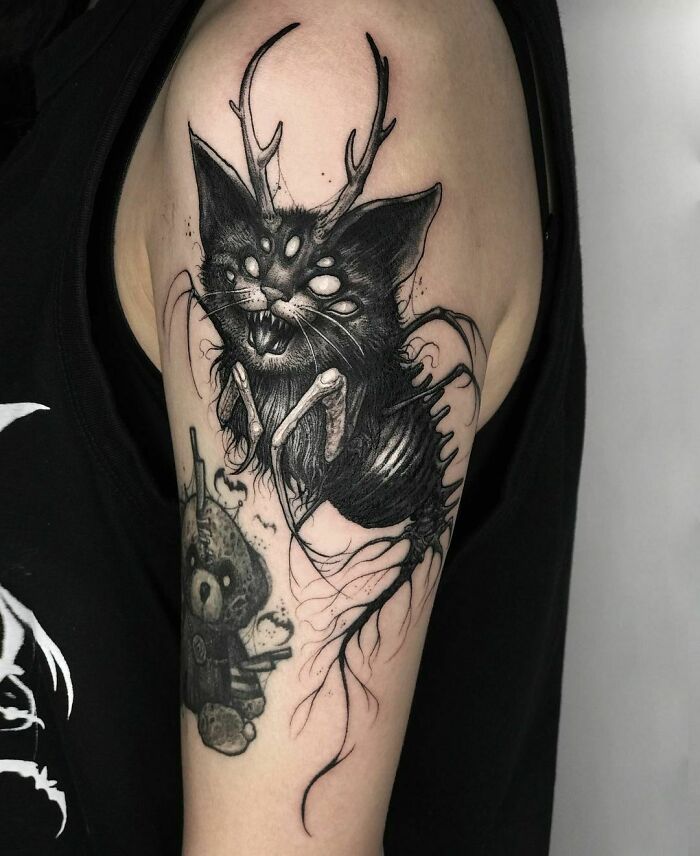 Spooky Cat with a weird body and horns upper arm Tattoo