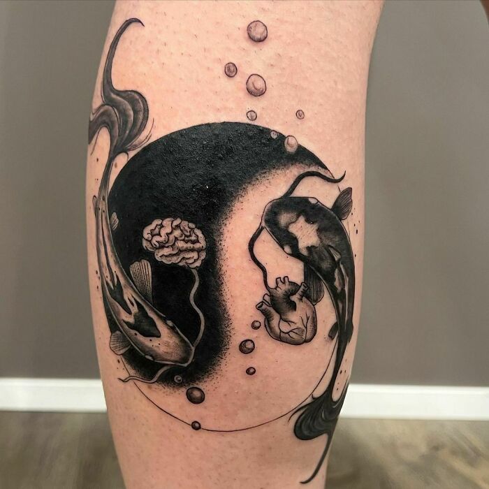 Two fishes around brain and heart forming yin yang symbol tattoo 