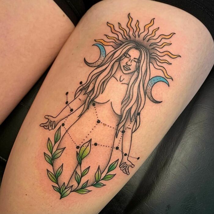 Zodiac tattoo of a celestial goddess with sun, moon, and constellation on skin.