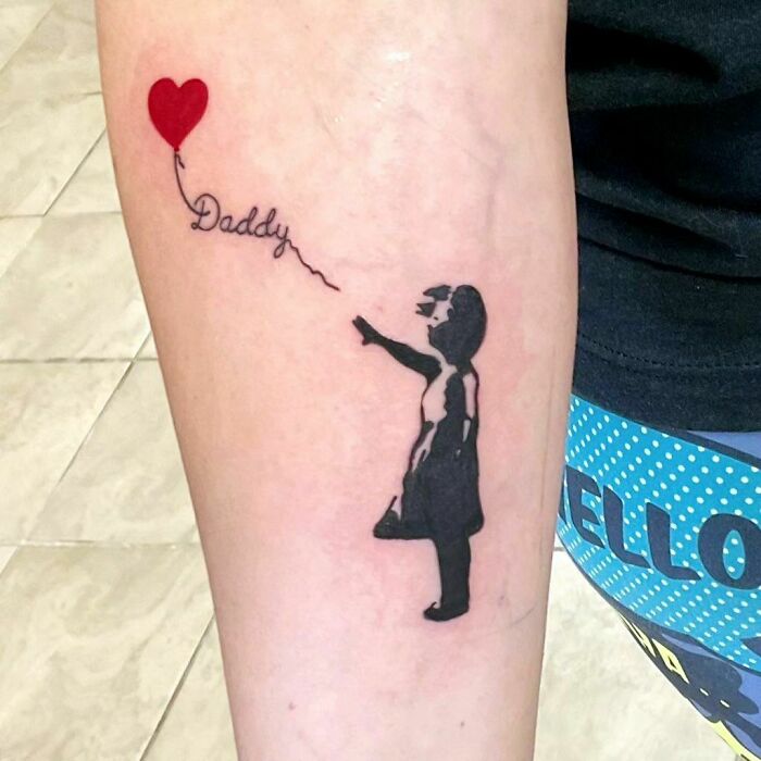 Girl with heart shaped balloon and word 'daddy' forearm tattoo