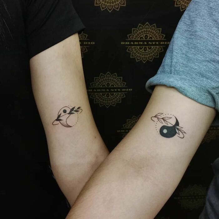 Matching yin yang arm tattoos 