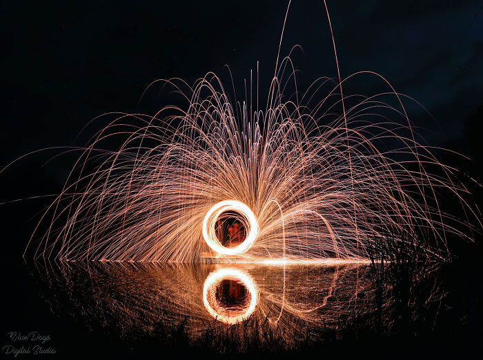 My (Now) Late Husband And I Spent July 4th Of 2020 Together Creating Photos Using "Painting With Light" Techniques. Me On The Bank Taking A Long Exposure Of Him Spinning Burning Steel Wool On A Paddle Boat In The Middle Of A Pond