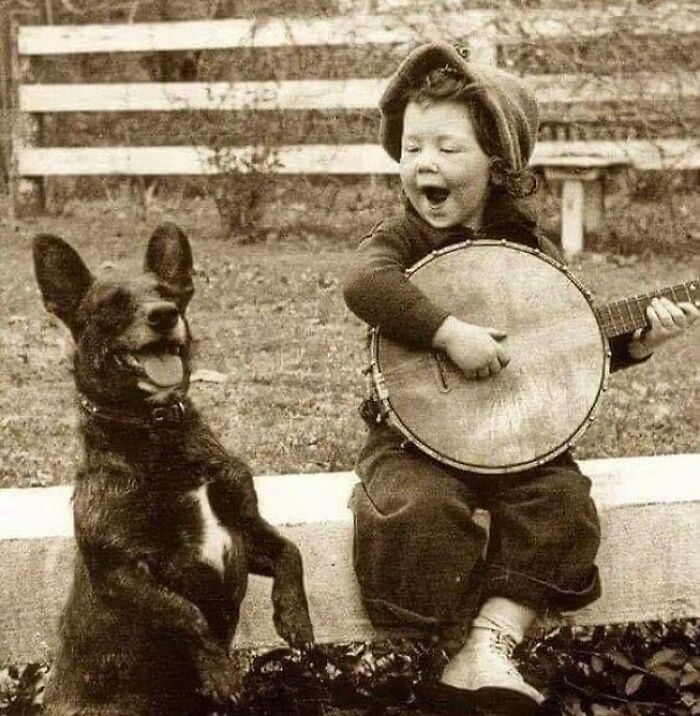 Chico tocando el banjo con su perro, principios del siglo XX