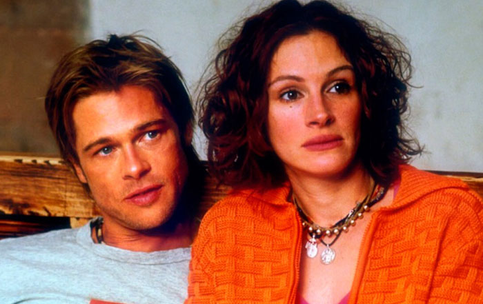 A man and a woman sitting together on a couch, both looking in the same direction with relaxed expressions. A man and a woman sitting together on a couch, both looking in the same direction with relaxed expressions.