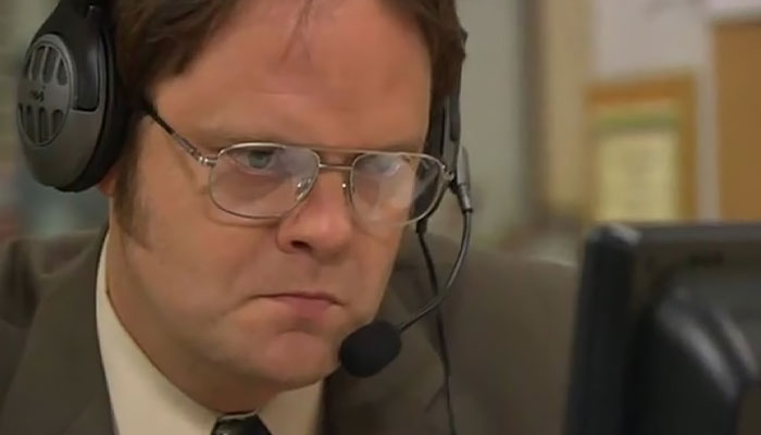 Dwight Schrute looking at a computer game passionately 
