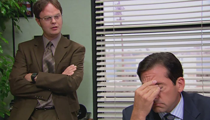Dwight Schrute telling something to micheal, micheal looking done