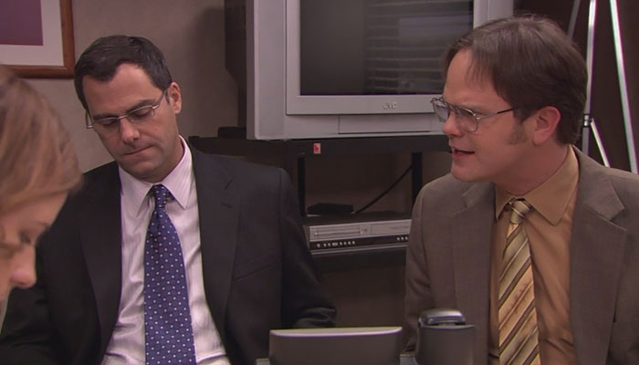 Dwight Schrute talking confidently at a meeting