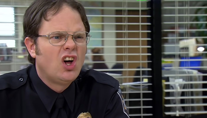 Dwight Schrute shouting with a judgmental expression