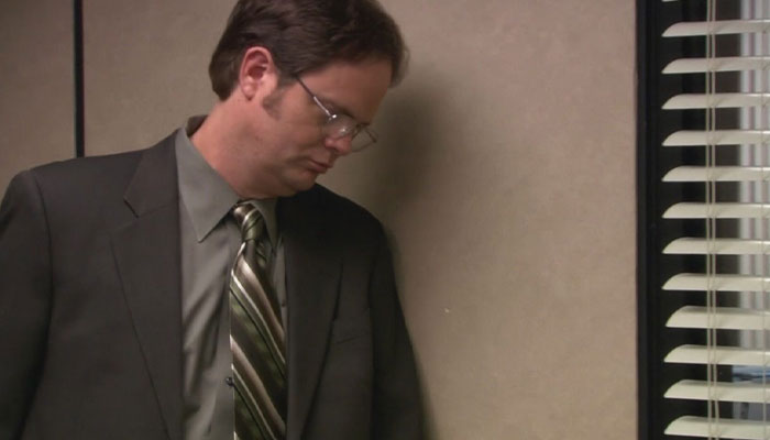 Dwight Schrute standing looking disappointed 