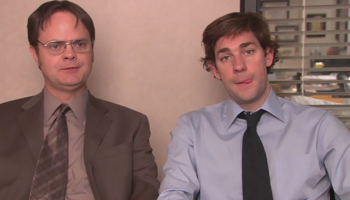 Dwight Schrute and Jim Halpert in the interview room looking a little silly