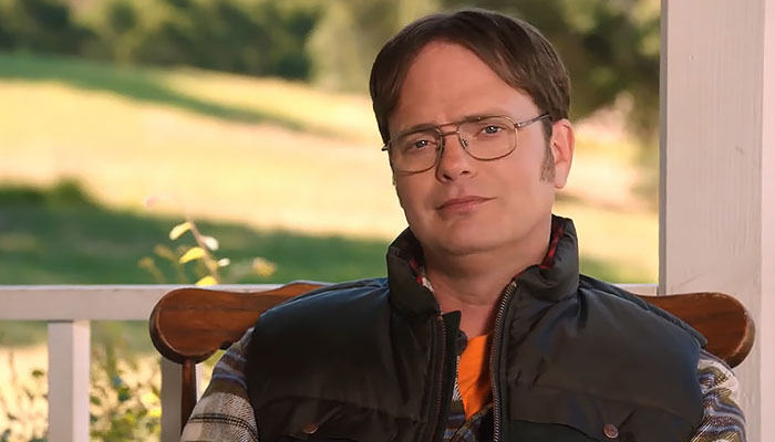 Dwight Schrute sitting outside with a proud expression
