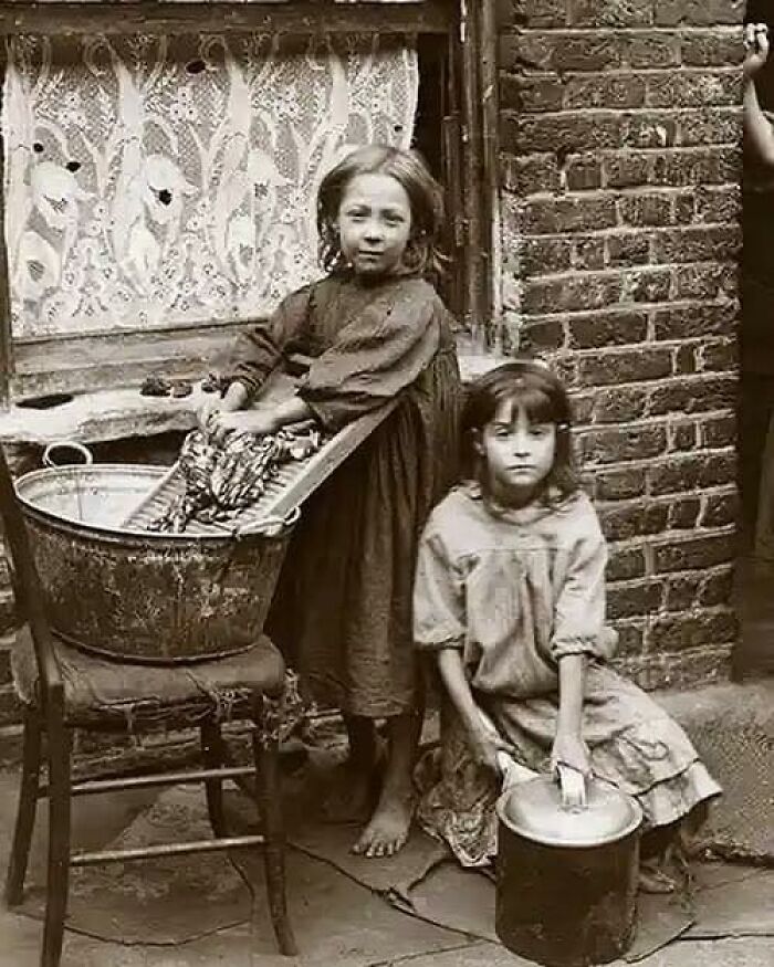 Portrait Of Two Girls Washing Clothes In The Street Of London, 1900s