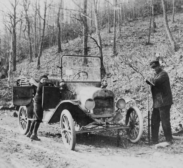 A Man And Boy Change A Tire On The Side Of A Dirt Road, 1917